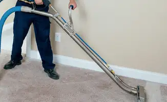 Professional operating a liquid removal machine on a carpeted floor in Omaha, NE
